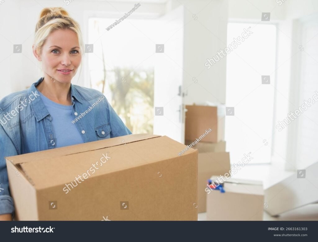 ihminen kantamassa muuttolaatikoita kotioven edessa