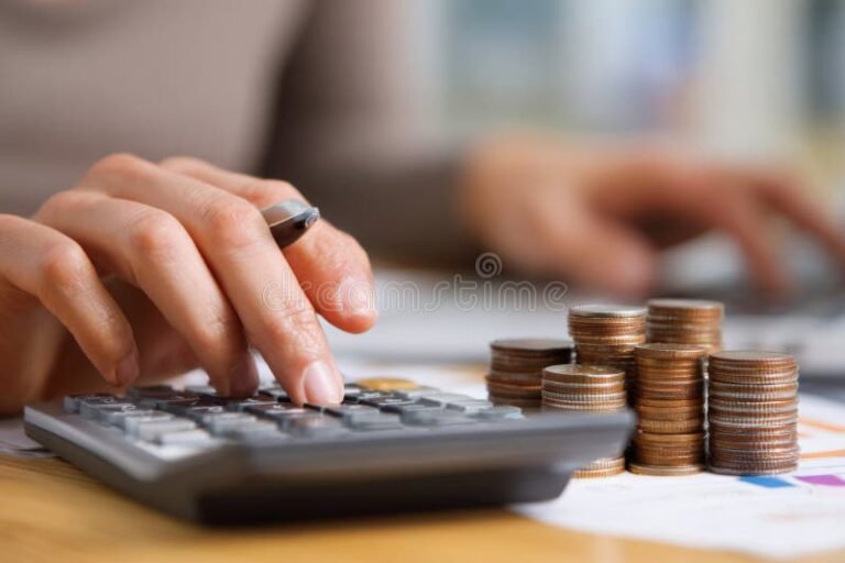 ihminen kayttaa laskinta poydan aaressa