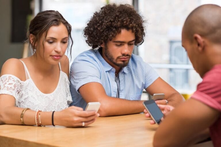 ihmiset katsovat mobiililaitteita keskustellen