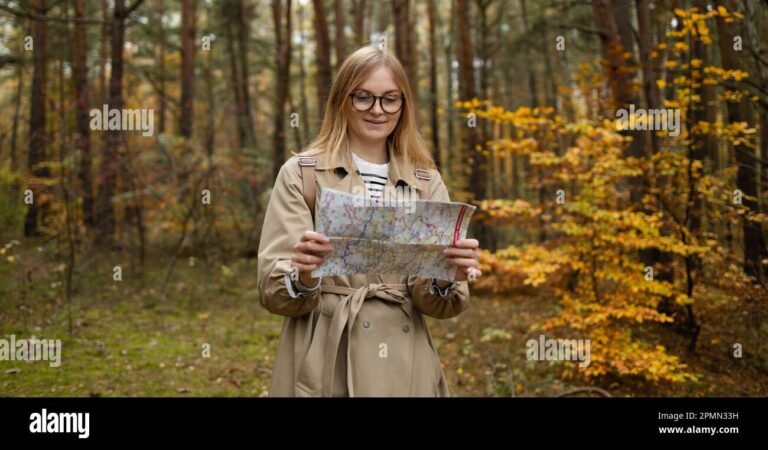 iloinen matkailija tutkii karttaa luonnossa