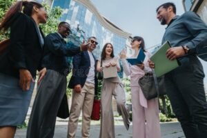 iloisia tyotovereita ulkona tiimityossa