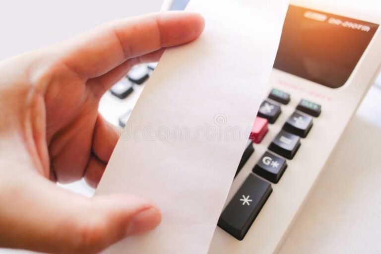 laskin ja paperi kadessa poydan aaressa