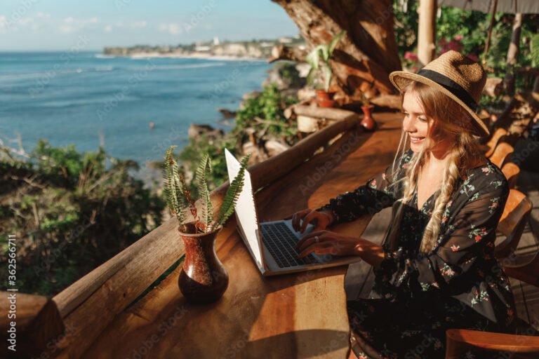 matkustaja kayttaa kannettavaa tietokonetta kahvilassa