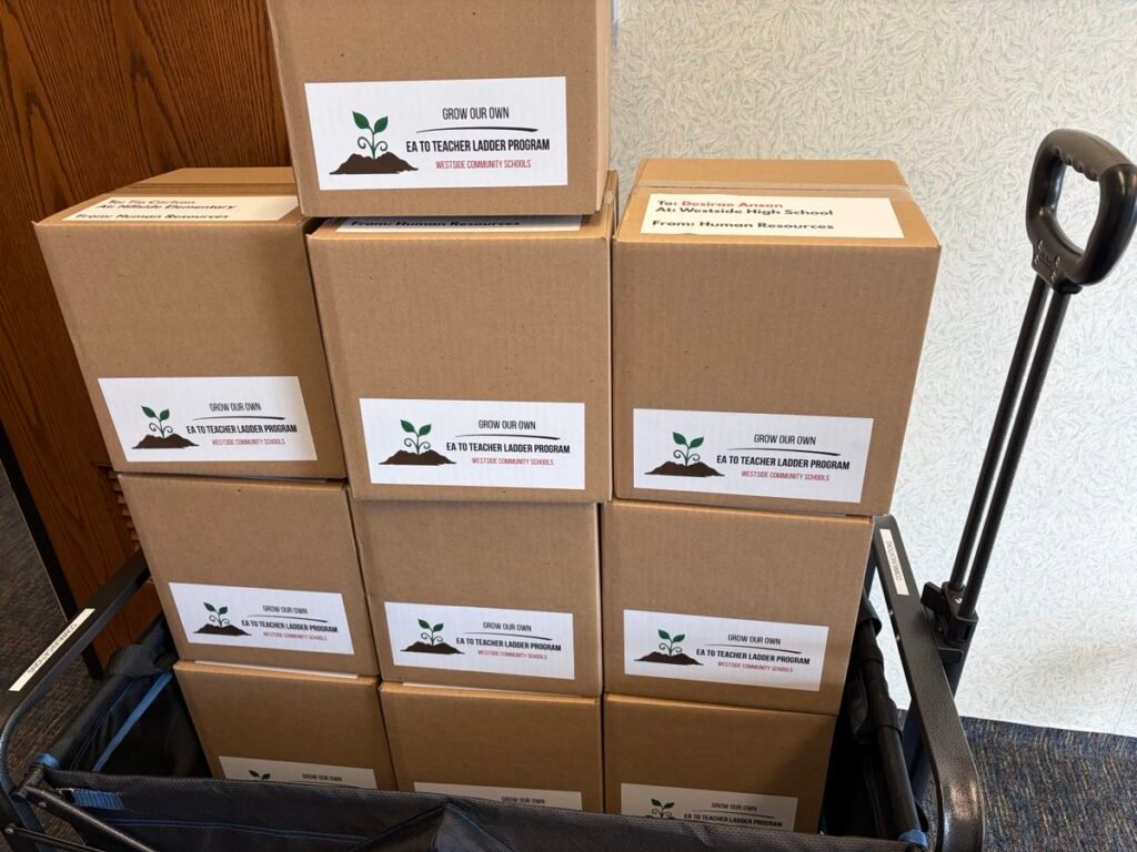 opettaja pakkaa koulutarvikkeita muuttolaatikkoon