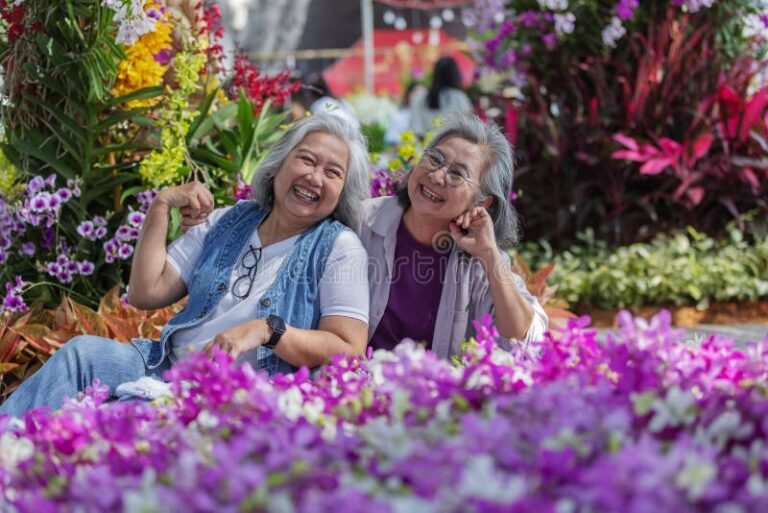 vanhempi nainen nauraa ystavansa kanssa luonnossa